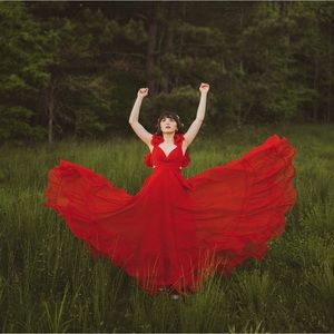 Tiered gown with side cutouts, a lace-up back, and ruffles at the shoulder.